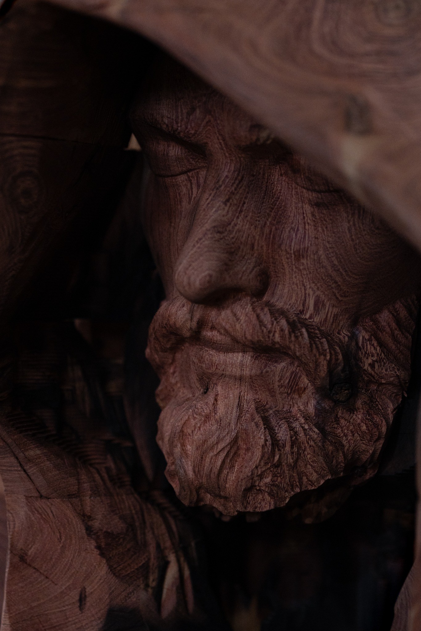 Primer plano del rostro tallado en madera de Jesucristo Mendigo.